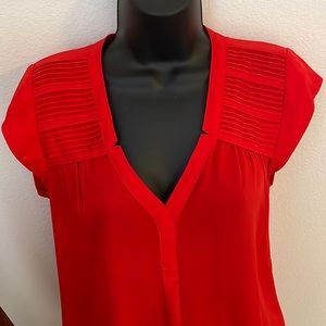 Red V-neck blouse with pleats on shoulders